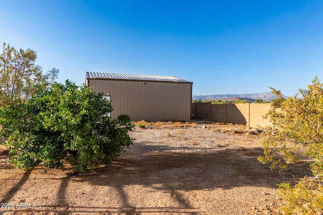 view of yard with an outbuilding, fence, and an outdoor structure