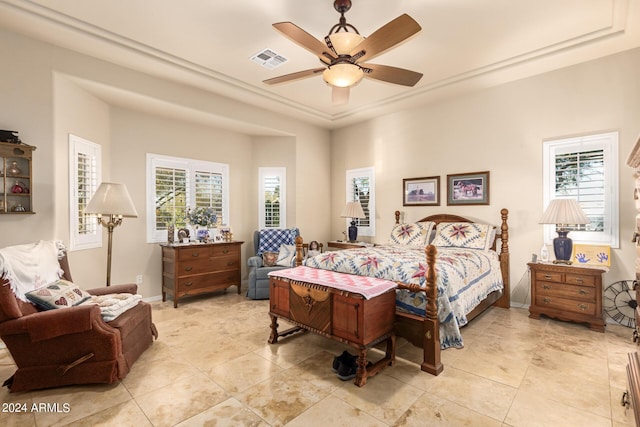 bedroom featuring a ceiling fan, a tray ceiling, visible vents, and baseboards