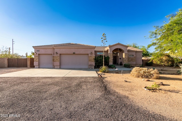 view of front facade with a garage, fence, a tile roof, driveway, and stucco siding