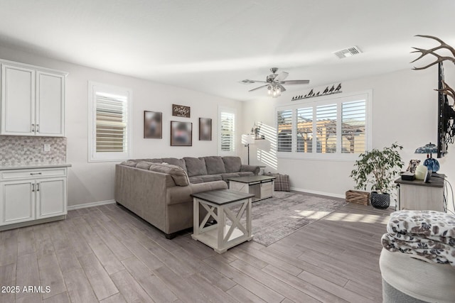 living room with ceiling fan, a healthy amount of sunlight, and light hardwood / wood-style floors