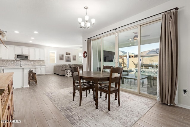 dining room featuring ceiling fan with notable chandelier