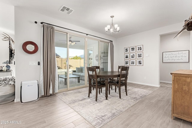 dining area featuring ceiling fan with notable chandelier and light hardwood / wood-style flooring