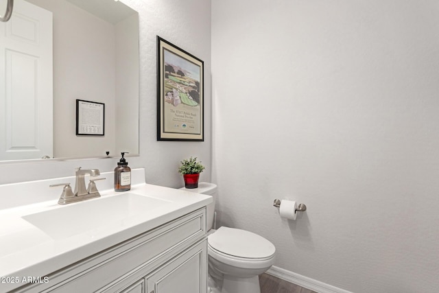 bathroom with vanity, toilet, and wood-type flooring