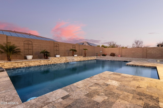 pool at dusk featuring a patio