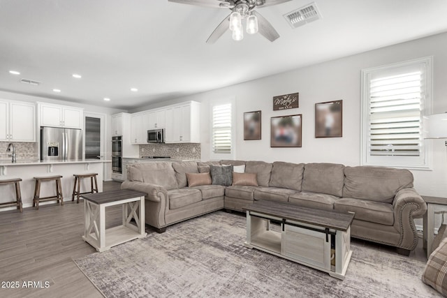 living room featuring hardwood / wood-style floors and ceiling fan