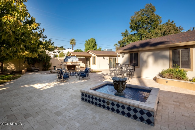 view of patio / terrace with an outdoor fireplace