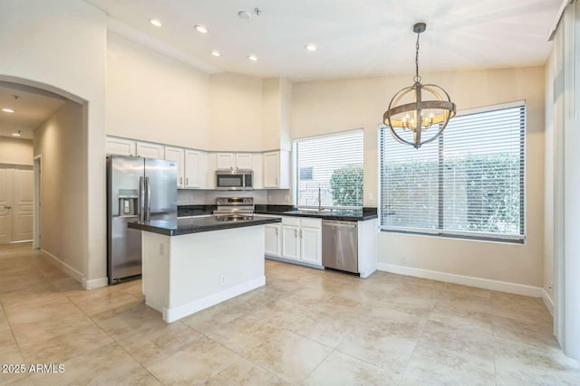 14452 N 98th Pl, Scottsdale, AZ 85260 - kitchen featuring appliances with stainless steel finishes, white cabinets, arched walkways, a center island, and a chandelier