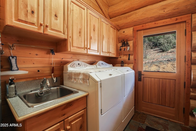 laundry room with separate washer and dryer, sink, log walls, and cabinets