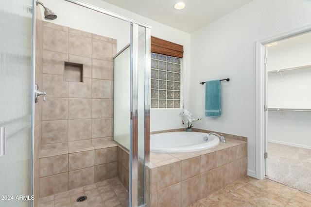 bathroom featuring tile patterned flooring and separate shower and tub