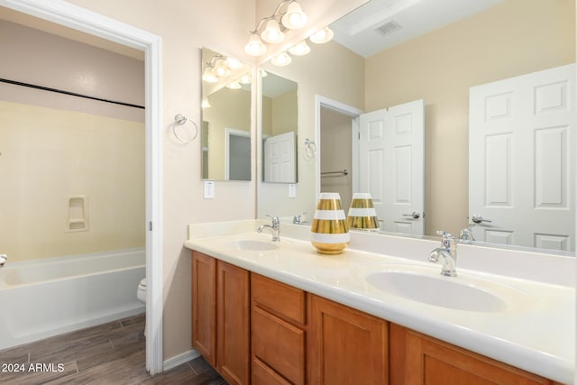 bathroom with toilet, vanity, and wood-type flooring