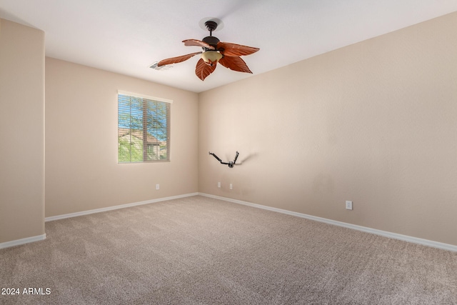 carpeted spare room with ceiling fan