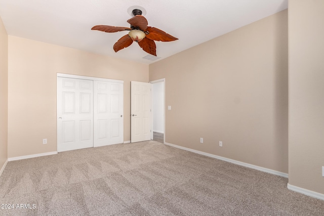 unfurnished bedroom featuring a closet, light colored carpet, and ceiling fan