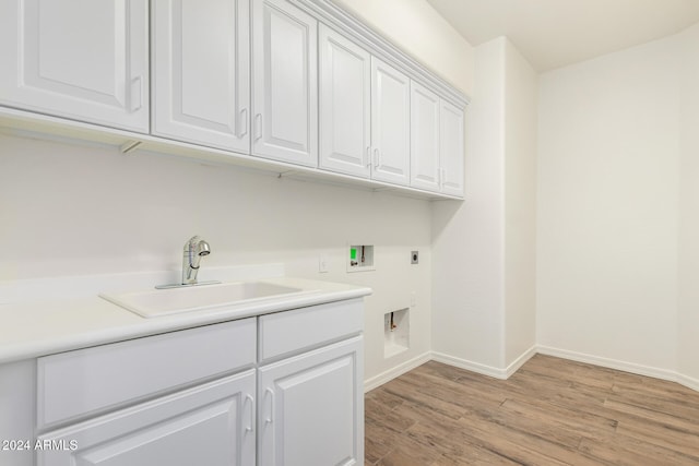 laundry area with hookup for an electric dryer, washer hookup, cabinets, sink, and light hardwood / wood-style floors