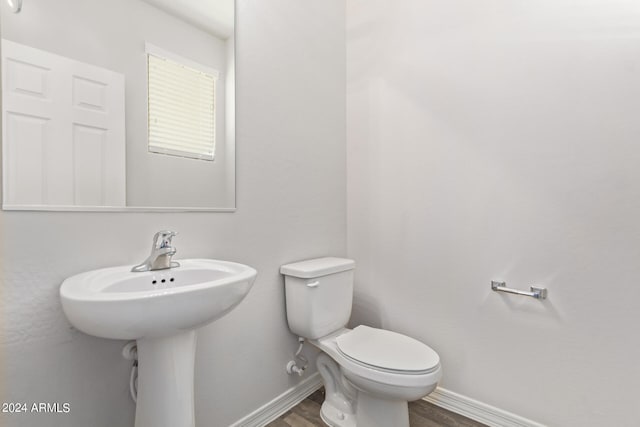 bathroom with hardwood / wood-style floors and toilet