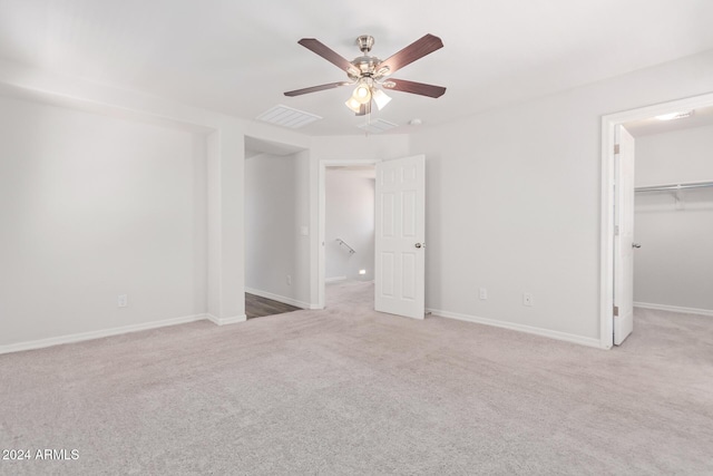 unfurnished bedroom with baseboards, a spacious closet, visible vents, and carpet flooring