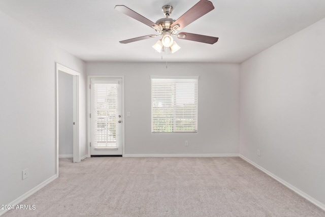 unfurnished room featuring baseboards, ceiling fan, and light colored carpet