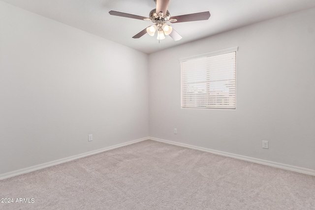 carpeted empty room featuring baseboards and a ceiling fan