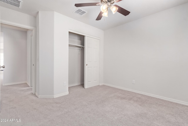 unfurnished bedroom featuring ceiling fan, a closet, and light carpet