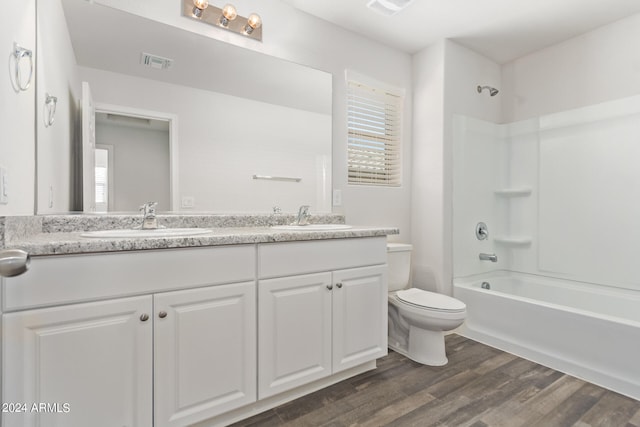 full bathroom with  shower combination, hardwood / wood-style floors, dual vanity, and toilet