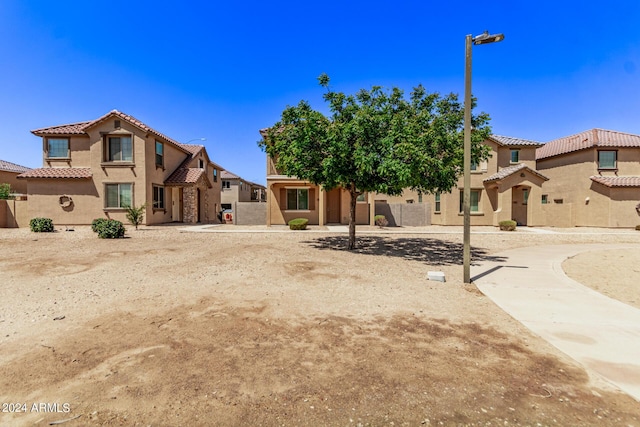 view of front of house with a tile roof, a residential view, and stucco siding