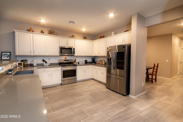 kitchen with sink, white cabinetry, and stainless steel appliances