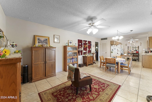 dining space featuring ceiling fan with notable chandelier, light tile floors, and a textured ceiling