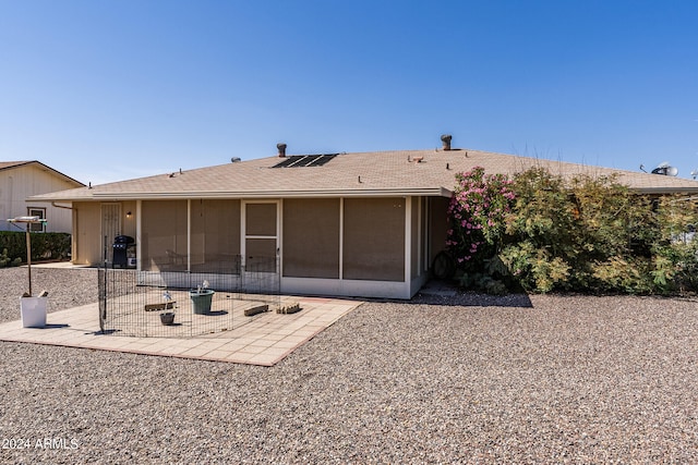 back of property featuring a patio, an outdoor fire pit, and a sunroom