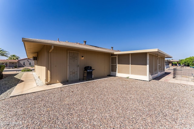 back of house with a patio area and a sunroom