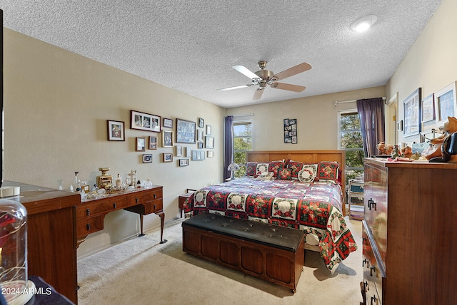 carpeted bedroom with ceiling fan and a textured ceiling