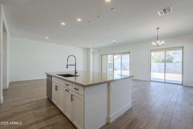 kitchen with sink, an island with sink, white cabinets, decorative light fixtures, and stainless steel dishwasher