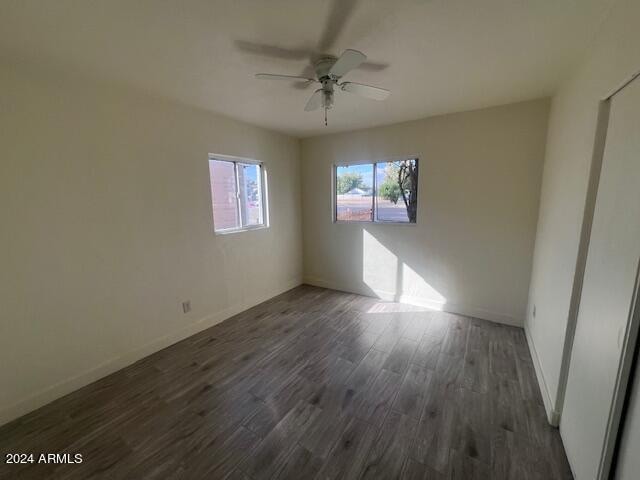 empty room featuring ceiling fan and dark hardwood / wood-style floors