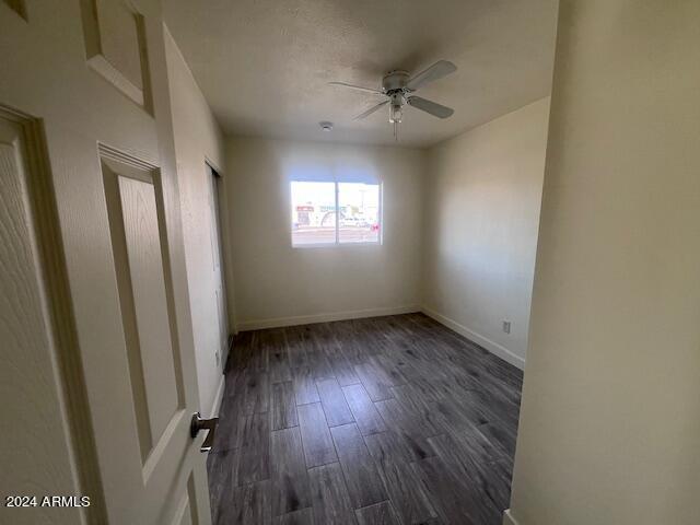 spare room featuring ceiling fan and dark wood-type flooring