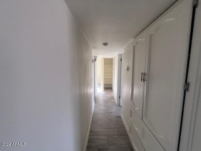 corridor with dark hardwood / wood-style flooring