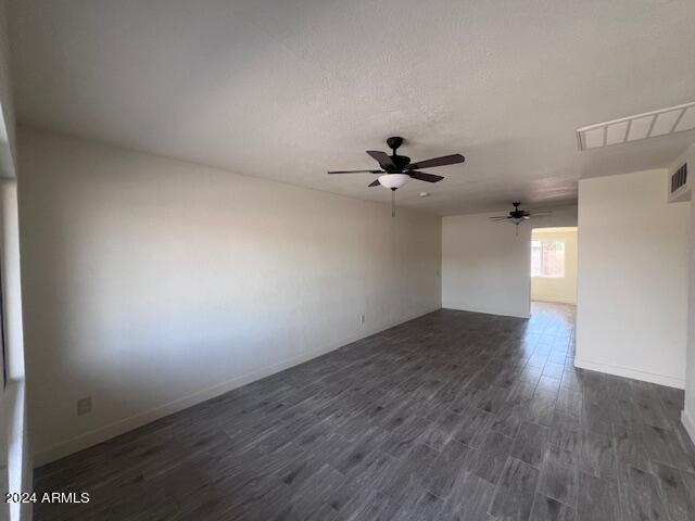 unfurnished room with ceiling fan and dark hardwood / wood-style flooring