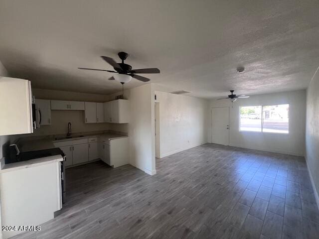 kitchen featuring wood-type flooring, white cabinets, sink, and ceiling fan