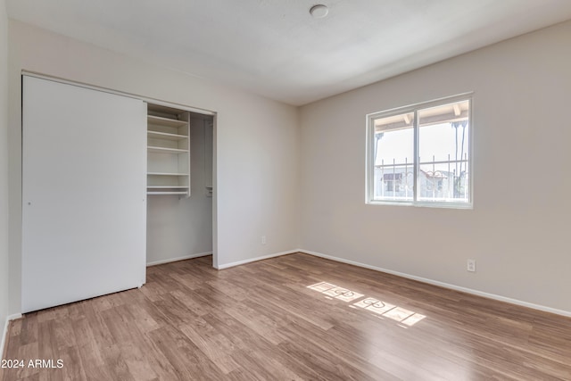 unfurnished bedroom featuring a closet and light wood-type flooring