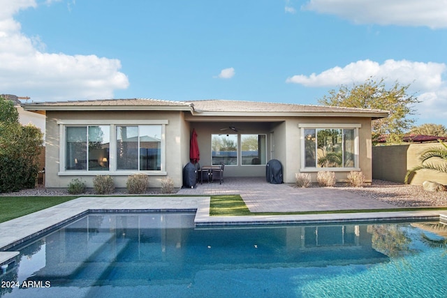 rear view of property featuring ceiling fan and a patio