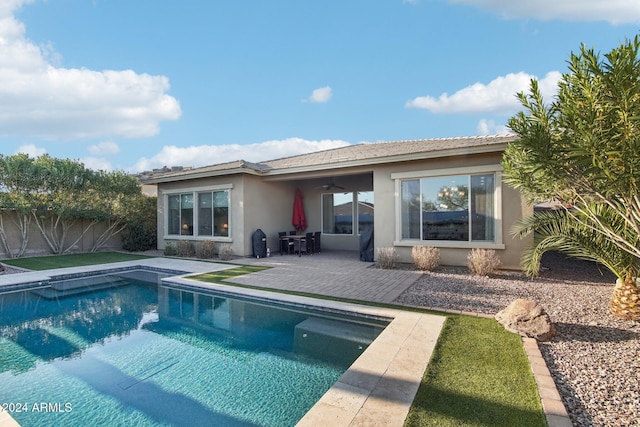 rear view of house featuring a patio, a fenced in pool, and ceiling fan