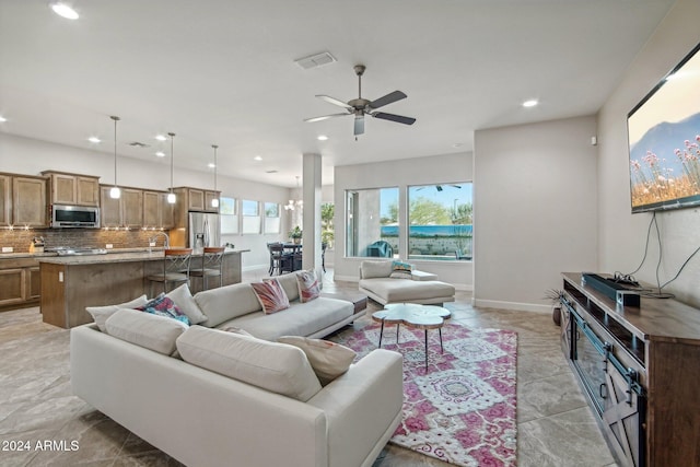 living room featuring ceiling fan with notable chandelier