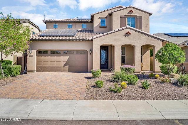 12932 W Cassia Trl, Peoria, AZ 85383 - mediterranean / spanish house with stucco siding, decorative driveway, a garage, solar panels, and a tile roof