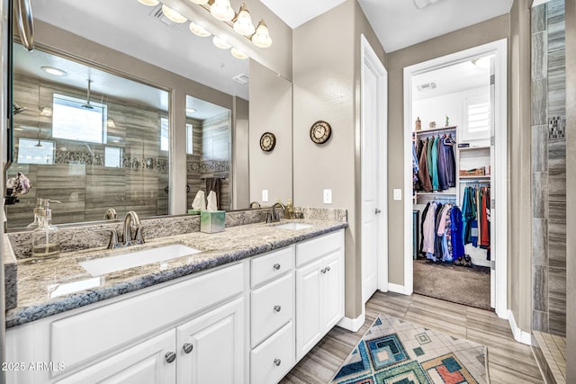 12932 W Cassia Trl, Peoria, AZ 85383 - bathroom featuring double vanity, a tile shower, and a spacious closet