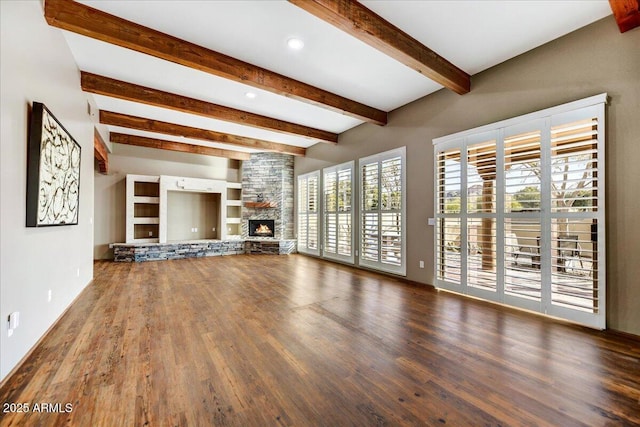 unfurnished living room featuring beamed ceiling, a stone fireplace, and dark wood-type flooring