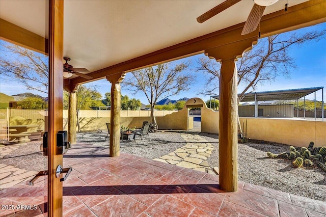 view of patio with ceiling fan and a fire pit