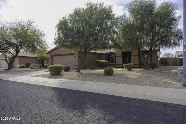 view of front of house with a garage, fence, a tile roof, driveway, and stucco siding