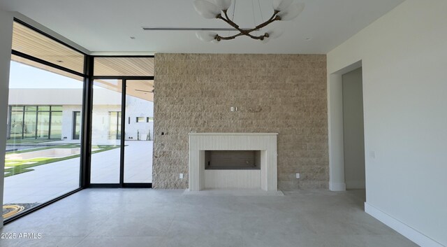 4644 E Indian Bend Rd, Paradise Valley, AZ 85253 - unfurnished living room with a chandelier, floor to ceiling windows, and a fireplace