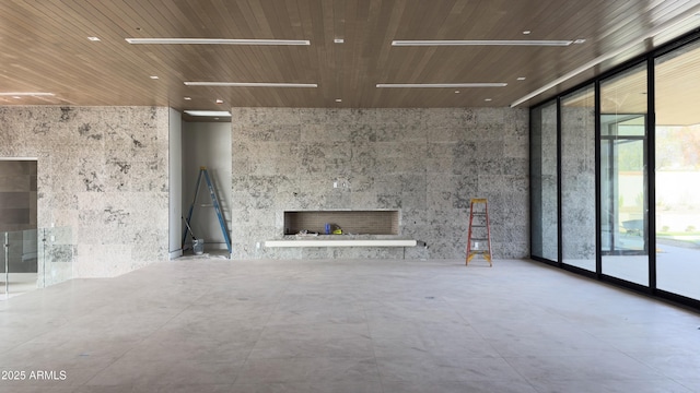 4644 E Indian Bend Rd, Paradise Valley, AZ 85253 - unfurnished living room with a fireplace, a wall of windows, recessed lighting, and wooden ceiling