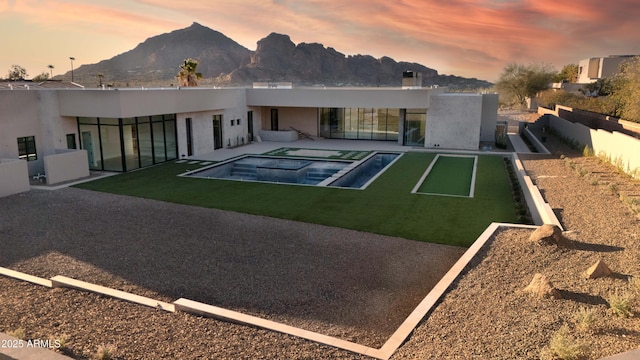 4644 E Indian Bend Rd, Paradise Valley, AZ 85253 - back of property at dusk featuring stucco siding, a patio, a mountain view, and a pool with connected hot tub