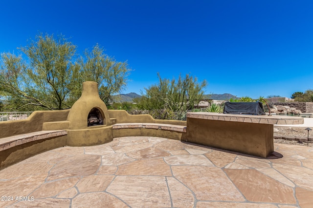 view of patio / terrace featuring a mountain view and exterior fireplace