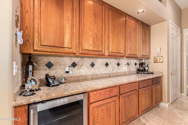 kitchen featuring backsplash, dishwasher, light tile flooring, and light stone countertops