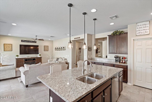 kitchen featuring hanging light fixtures, sink, a textured ceiling, a center island with sink, and dishwasher